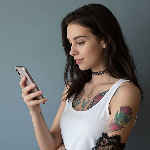 Young Woman with Tattoos and Smartphone