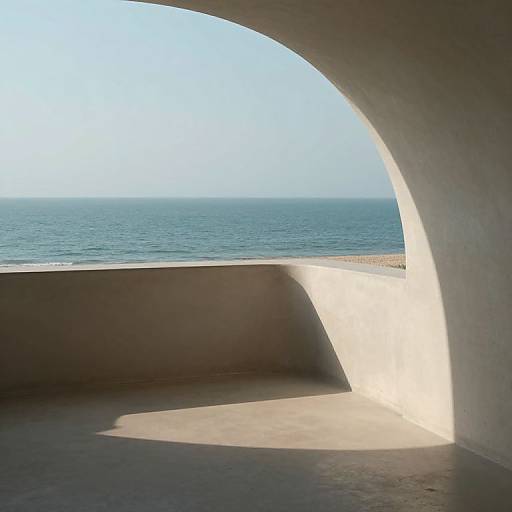 Photograph of a sunlit, arched stone balcony overlooking a calm, blue ocean under a clear sky. Shadows cast on the balcony floor.