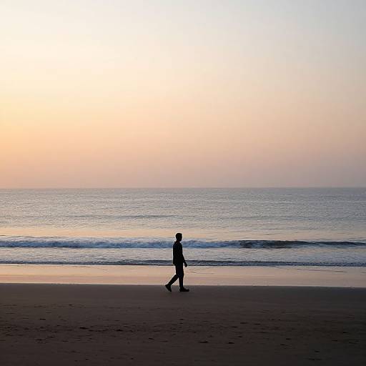 Silhouetted figure walking along a serene beach at sunset, with gentle waves and a gradient sky from pale orange to blue.