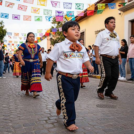 Colorful Mexican street festival: Young boy in white shirt and black pants with ornate embroidery walks barefoot, surrounded by adults in traditional clothing, under