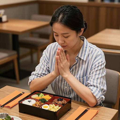 Praying Asian Woman at a Cozy Table