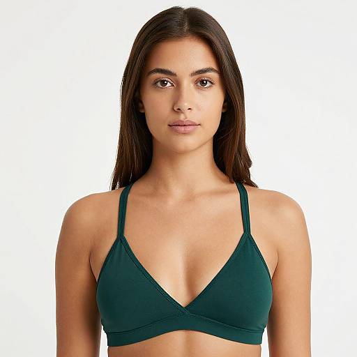 Photograph of a young woman with long dark brown hair, medium skin tone, wearing a dark green sports bra, centered against a plain white background.