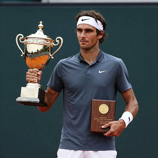 Male Tennis Player Holding Trophy and Plaque