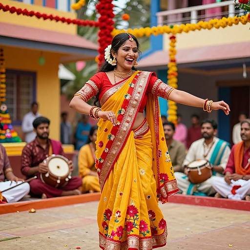 Photograph of a smiling Indian woman in a vibrant yellow sari with red and gold floral embroidery, dancing in a colorful, decorated courtyard with musicians in