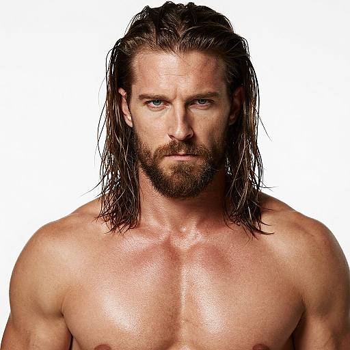 Photograph of a muscular, shirtless man with wet, shoulder-length brown hair, blue eyes, and a full beard, staring intensely at the camera