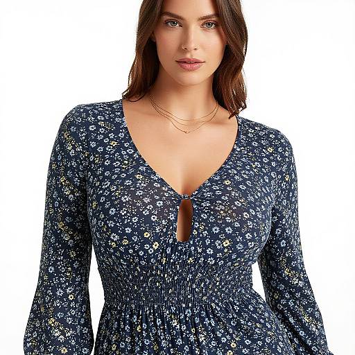Photograph of a young woman with medium-length brown hair, wearing a navy blue floral dress with a V-neck and keyhole cutout, and two