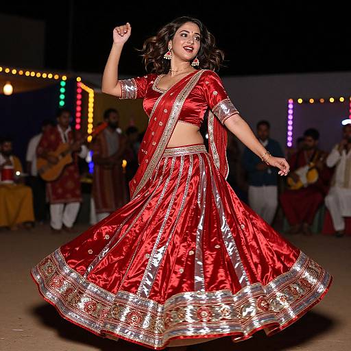 Photograph of a smiling Indian woman in a vibrant red, silver-embroidered traditional lehenga, dancing on a stage with colorful lights in the