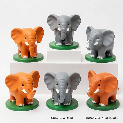 Photograph of three elephant figurines: orange, gray, and another orange elephant, standing on green bases, with white background labels.