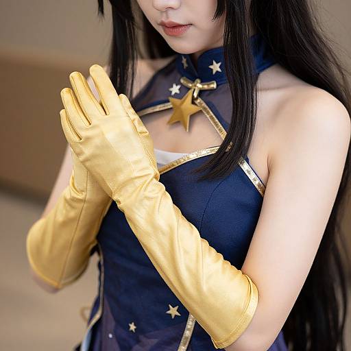 Photograph of an Asian woman in a black, star-patterned cosplay outfit, wearing long, shiny gold gloves, with long black hair, hands raised