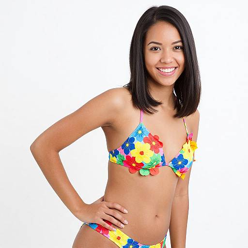 Photograph of a smiling young woman with straight black hair, wearing a colorful floral bikini, standing against a white background.