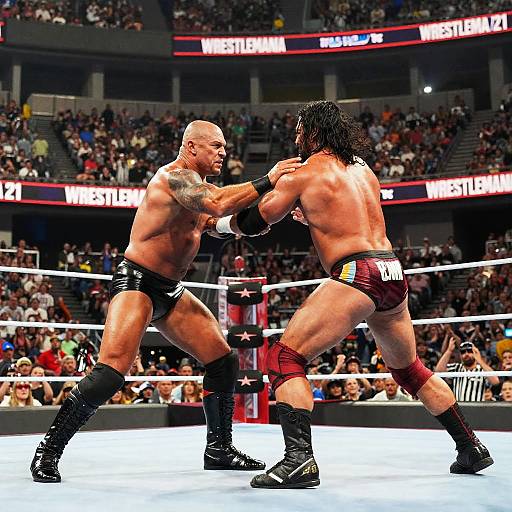 Photograph of intense boxing match: muscular bald man with tattoos in black trunks and boots vs. dark-haired man in red trunks, fighting in