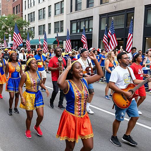Photograph of diverse parade participants in colorful American-themed costumes, holding flags, marching down a city street with buildings in background.