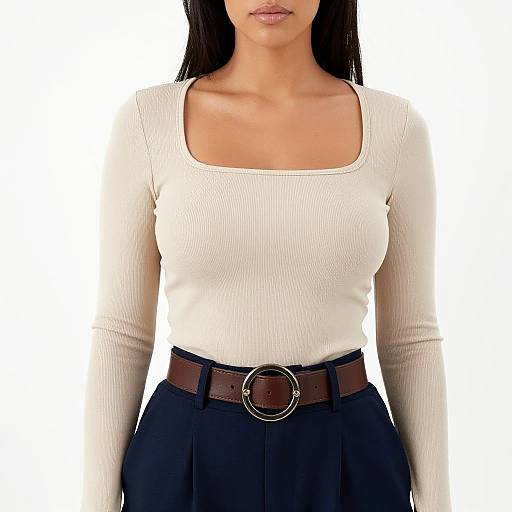 Photograph of a woman with long black hair, white ribbed long-sleeve top, and dark navy high-waisted skirt, wearing a