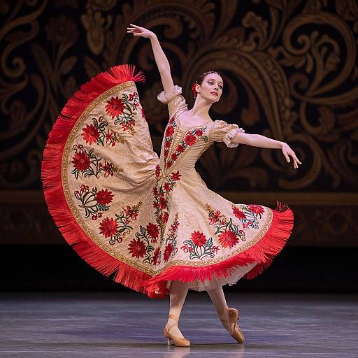 Ballet dancer in a flowing, cream and red floral dress with tassels, poised elegantly on stage, arms gracefully extended.