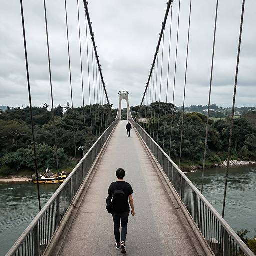 Photograph of a man with a backpack walking on a suspension bridge, leading to a distant white archway, surrounded by trees and a river with a