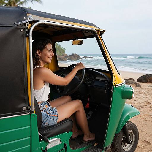 Photograph of a smiling woman with tanned skin and brown hair, wearing a white tank top and blue shorts, driving a green auto-rickshaw