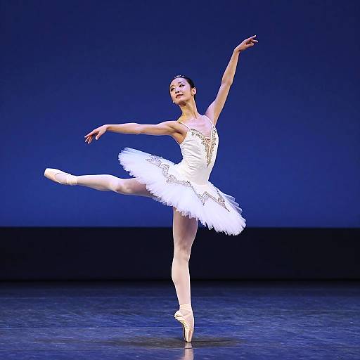 Photograph of a graceful ballerina in a white tutu, pointe shoes, and sparkling bodice, performing a graceful arabesque on