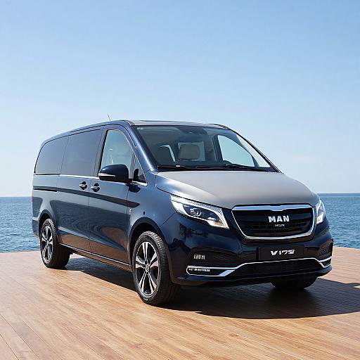 Photograph of a sleek, black Mazda Vansport Minivan parked on a wooden dock against a clear blue sky and sea background.