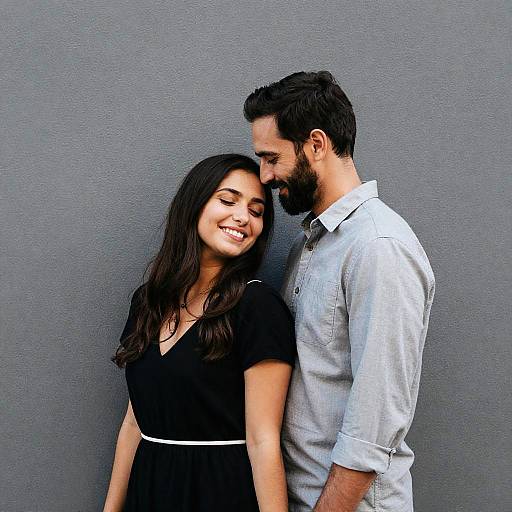 Joyful Couple Against Gray Wall