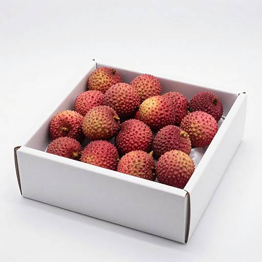 Photograph of a white cardboard box filled with vibrant red and orange dragon fruit with spiky, textured skin.