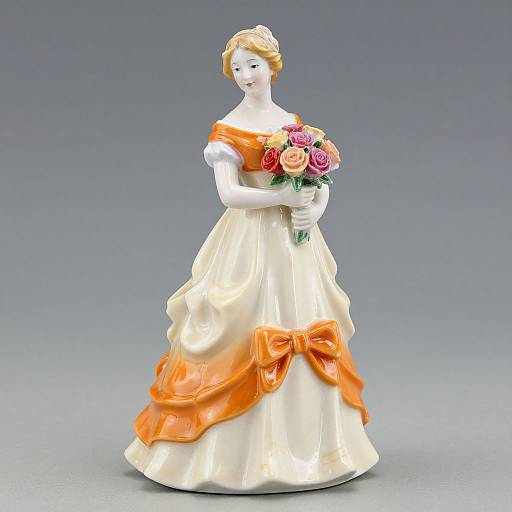 Photograph of a porcelain bride figurine wearing an off-shoulder, cream gown with vibrant orange sash and bow, holding a bouquet of pink