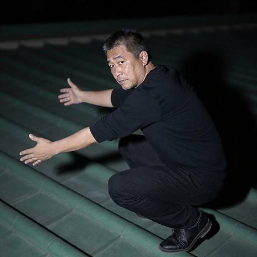 Man Crouching on Green Tiled Roof at Night