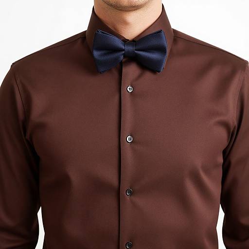 Photograph of a man's chest to neck, wearing a dark maroon dress shirt with black buttons and a navy blue bow tie. White background.