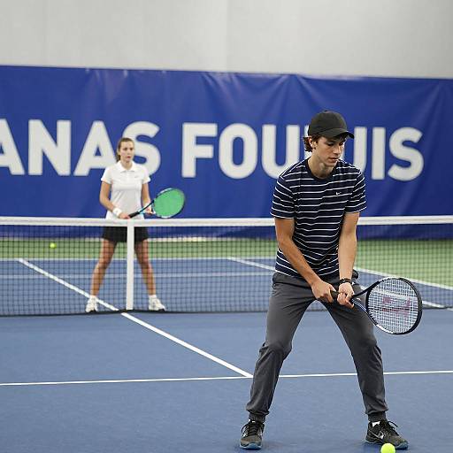 Young man and woman playing indoor tennis