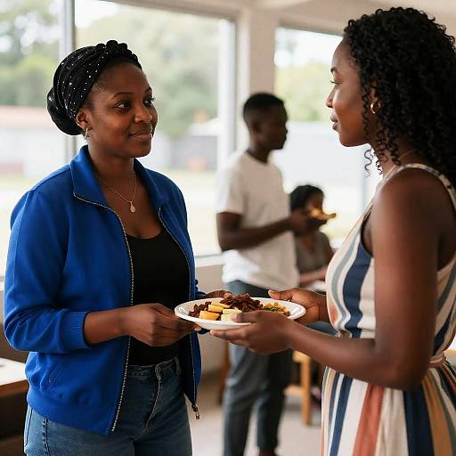 Two African-American Women Sharing Food Indoors