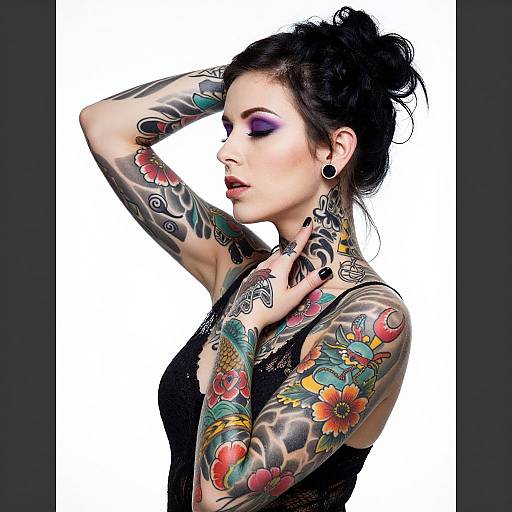 Photograph of a tattooed woman with dark hair in a bun, wearing black lace, purple eyeshadow, and black earrings, against a white