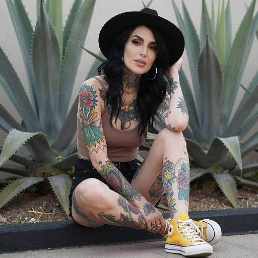 Tattooed Woman Sitting Among Succulents