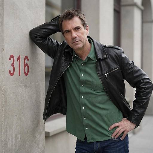 Middle-Aged Man Leaning on Wall in Urban Setting