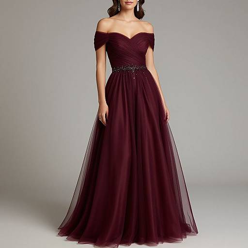 Photograph of a woman in an off-shoulder, floor-length, deep purple, tulle gown with a beaded belt, standing against a