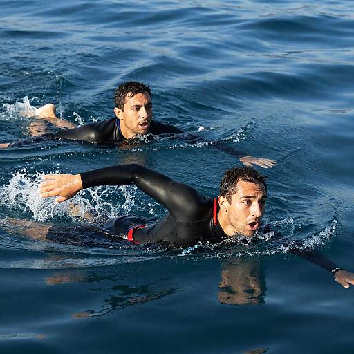 Two Men Swimming in Ocean with Wetsuits