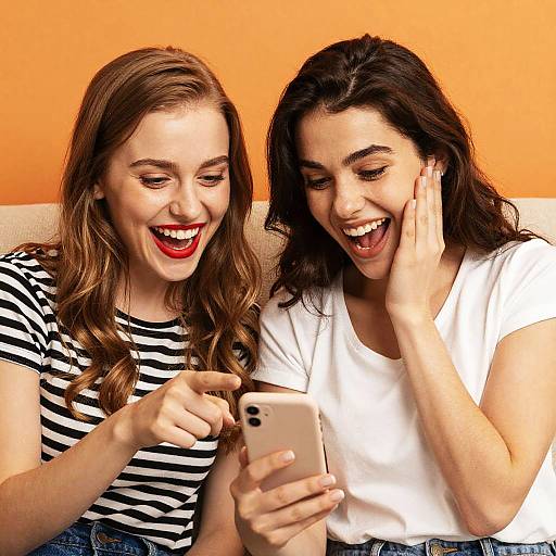 Two Excited Young Women Looking at Smartphone