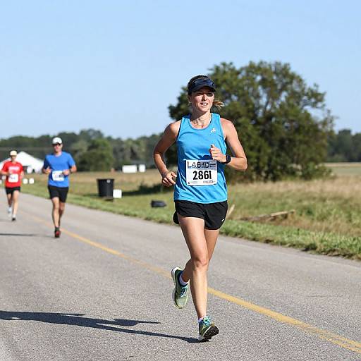 Photograph of a woman in a blue tank top and black shorts, race bib 