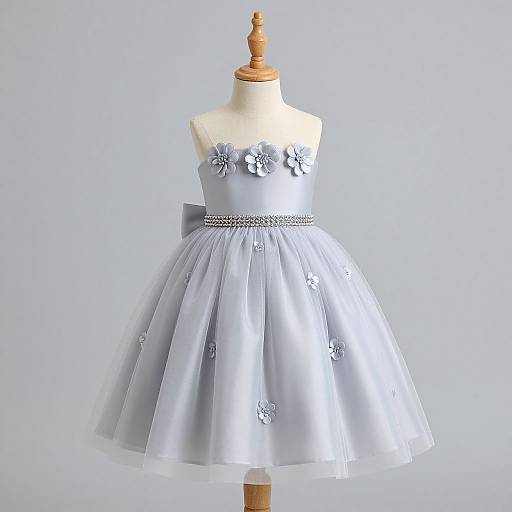 Photograph of a light blue, strapless, floral-embellished, satin tulle dress on a wooden dress form against a plain white background