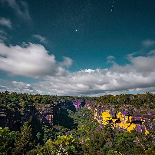 Photograph of a vibrant canyon landscape with green foliage, bright yellow rock formations, dramatic clouds, and a shooting star in the night sky.