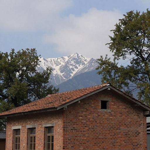 Rustic Red Brick Building with Snow-Capped Mountain