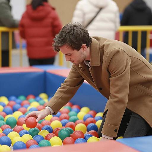 Man Reaching for Ball in Colorful Pit