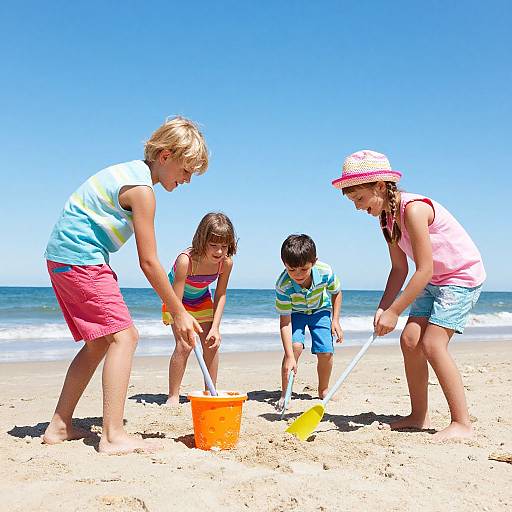 Photograph of four children playing on a sunny beach with clear blue sky, wearing colorful clothes, digging in sand with buckets.