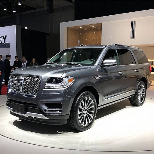 Photograph of a sleek, metallic gray Infiniti SUV displayed on a brightly lit showroom floor with a modern, minimalist background.