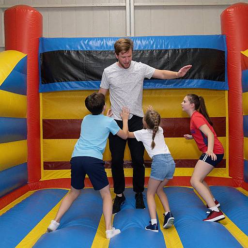 Adult Playfully Bouncing with Kids in Inflatable Castle