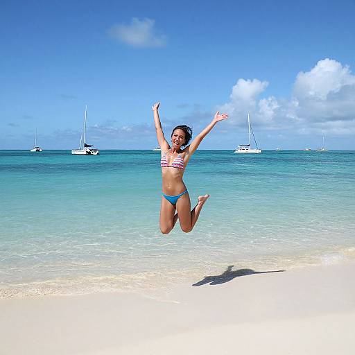 Photograph of a joyful woman with medium brown skin, dark curly hair, wearing a red and white striped bikini and blue bottoms, mid-air jump on