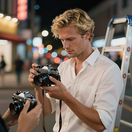 Blonde Man with Vintage Cameras on Urban Night Street