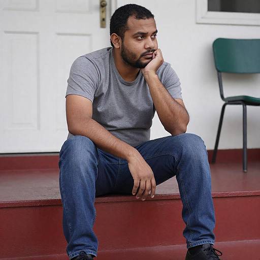 Contemplative Man Sitting on Red Steps