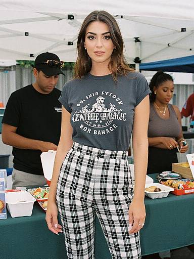 Photograph of a young woman with long brown hair, wearing a gray 