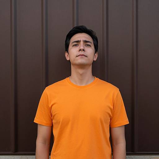 Man in Orange Shirt by Metal Wall