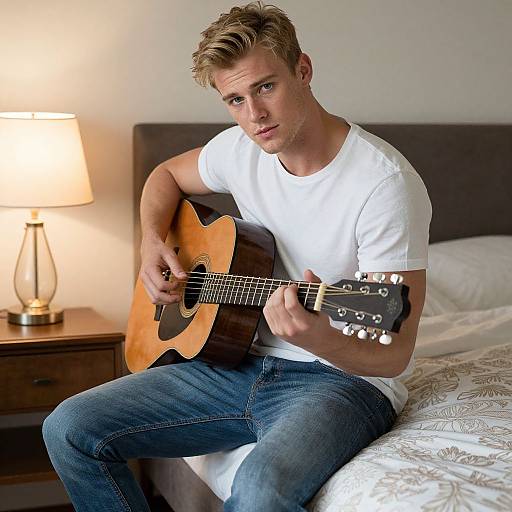 Young Man Playing Guitar on Bed
