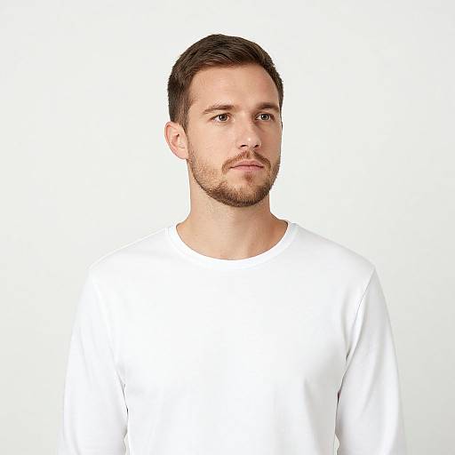 Photograph of a young, fair-skinned man with short brown hair, light beard, and mustache, wearing a plain white shirt, against a